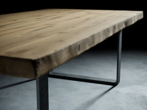 Tischplatte aus Altholz Eiche, geschliffener Oberfläche und originaler Balkenkante auf zwei Rohstahlframes