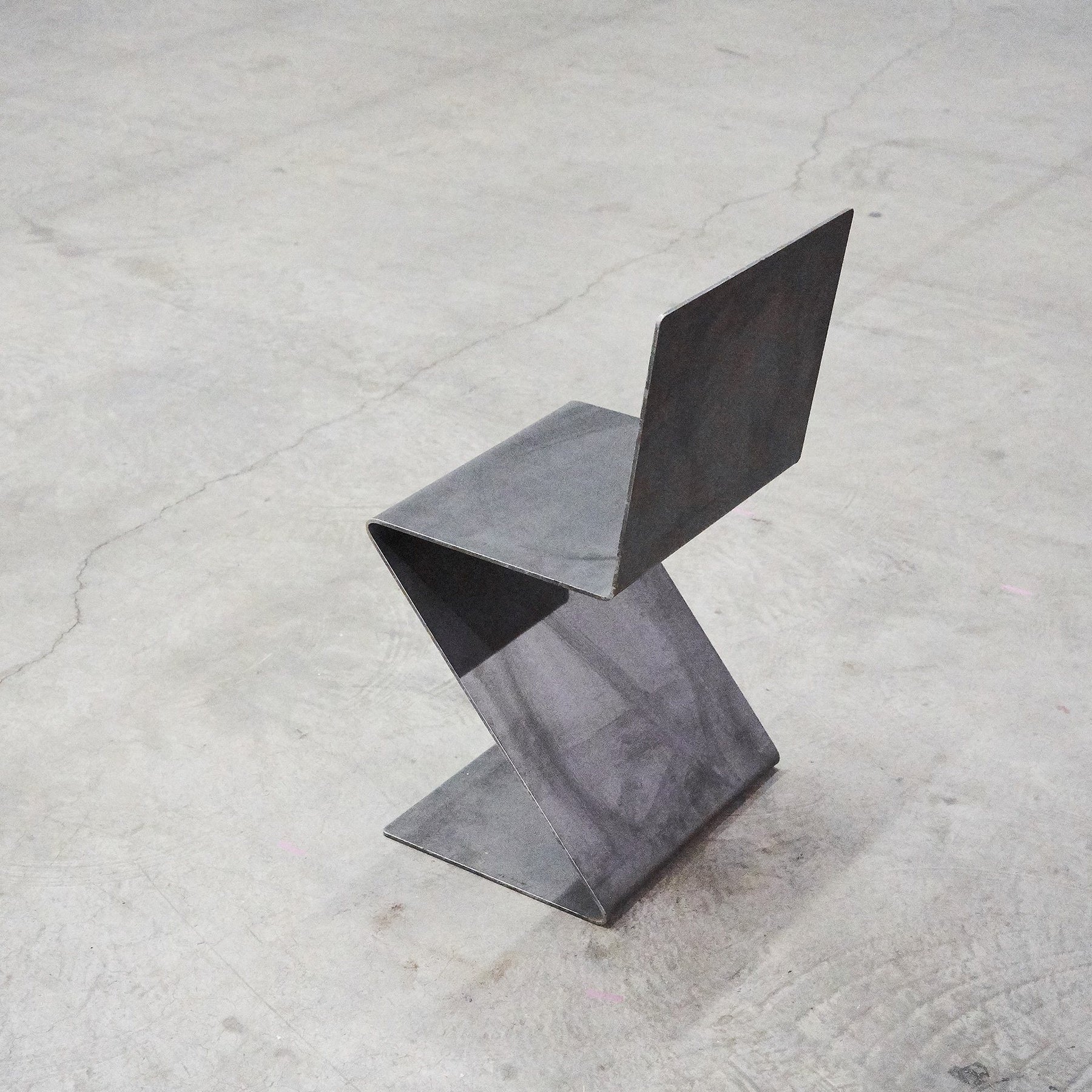 Freischwinger aus rohem Flachstahl und Rückenlehne, gefertigt aus einem Stück Flachstahl ohne Schweißnaht auf Betonboden